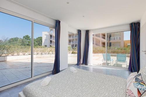 une chambre avec un lit et une grande fenêtre dans l'établissement Serenity apprt, à Théoule-sur-Mer