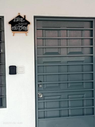 a green door with a sign on a building at Homestay Atok Mus'lim Only in Jenjarum