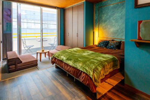 a bedroom with a bed and a chair and a window at Villa Boushu KURAMAE in Tokyo
