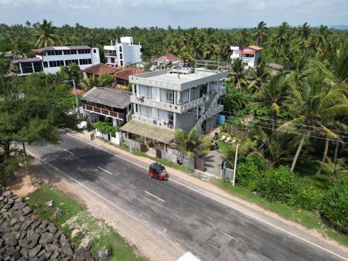 a car driving down a road in front of a building at The Stables Oceanfront Hotel Midigama in Midigama