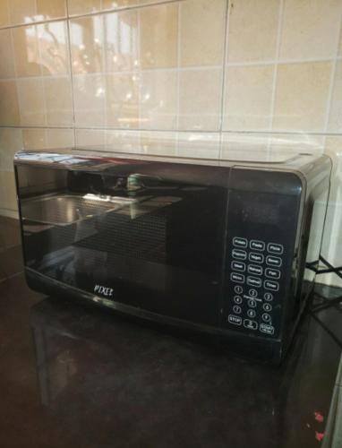 a black microwave sitting on top of a counter at The Urban Oasis Ntinda in Nalakonge