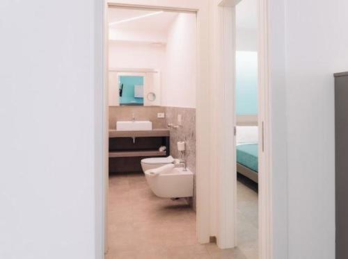 a bathroom with a sink and a toilet and a mirror at Holiday Apartments Campoverde in Salò