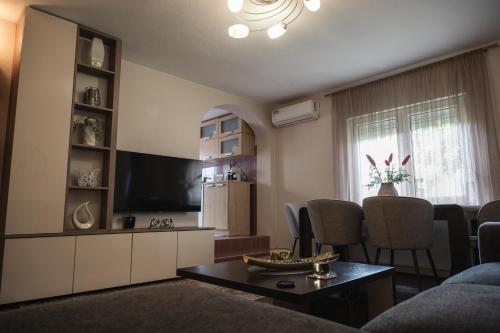 a living room with a couch and a tv and a table at Gajic & Milini in Banja Luka