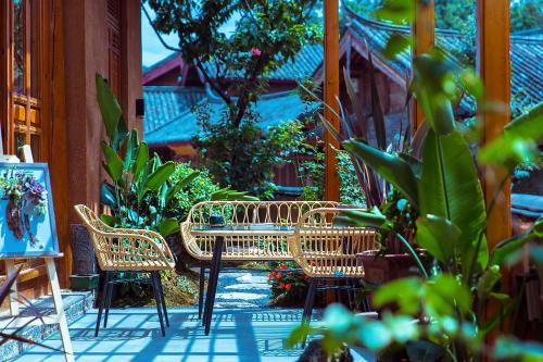 a patio with a table and chairs and plants at Lijiang half yard hotel in Lijiang