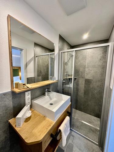 a bathroom with a sink and a shower at Alpenhotel Hundsreitlehen in Bischofswiesen