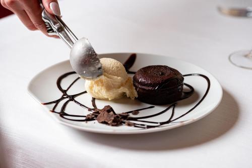 a plate with chocolate and ice cream on a table at Phi Hotel Astoria in Susegana