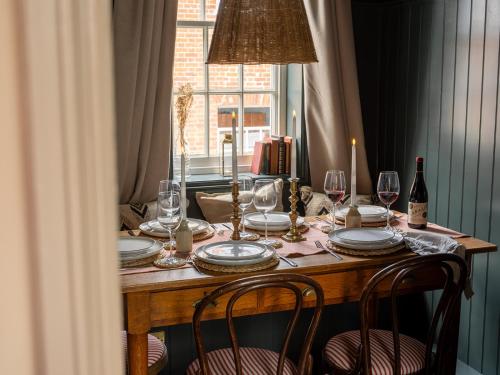 a table with glasses and plates and a lamp at Chapman House 3 Bedroom Luxury Retreat in Norwich