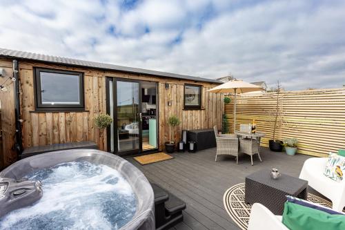 a hot tub on the deck of a house at Willows Rest - 1 Bed Shepherds Hut - Pentlepoir in Saundersfoot