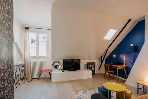 - un salon avec une télévision sur un meuble blanc dans l'établissement L'Escapade - Superbe appartement cosy coeur de Nantes, à Nantes