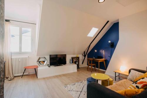 un salon avec un canapé et une télévision dans l'établissement L'Escapade - Superbe appartement cosy coeur de Nantes, à Nantes