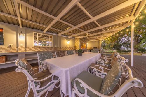 a dining room with a white table and chairs at Room 1 - LEO Sky Guest House in Simondium