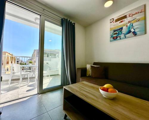 una sala de estar con sofá y un bol de fruta en una mesa en Serene Napa Suites - Heart of Ayia Napa, en Ayia Napa