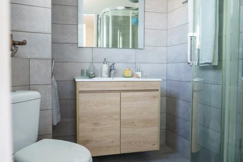 a bathroom with a sink and a toilet and a mirror at Nostos in Hydra