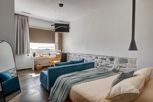 a bedroom with a bed and a blue couch at NOS Suites in Ermoupoli