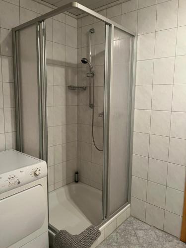 a shower with a glass door in a bathroom at Ferienwohnung Anne in Großheide