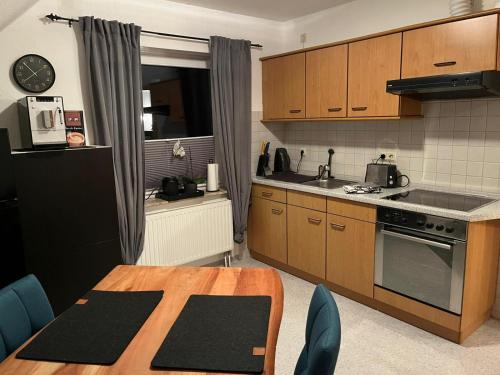 a kitchen with wooden cabinets and a wooden table with a table sidx sidx at Ferienwohnung Anne in Großheide