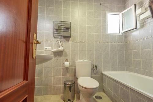 a bathroom with a toilet and a tub and a sink at Casa Susan, Penthouse apartment, view over Old Town & the Sea in Vejer de la Frontera