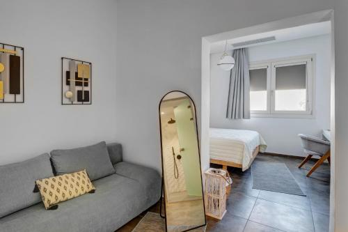 a living room with a couch and a mirror at NOS Suites in Ermoupoli
