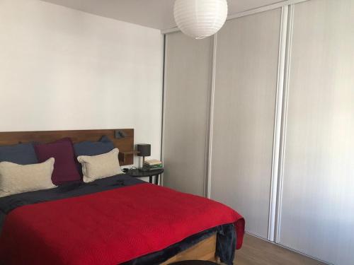 - une chambre avec un lit rouge et une couverture rouge dans l'établissement Deux Pièces des Arts-et-Métiers, à Paris