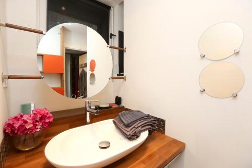 une salle de bain avec un lavabo blanc et un miroir dans l'établissement Deux Pièces des Arts-et-Métiers, à Paris