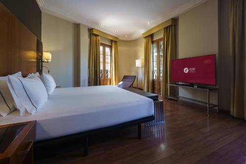 a bedroom with a large bed and a flat screen tv at Exe Almería Centro in Almería
