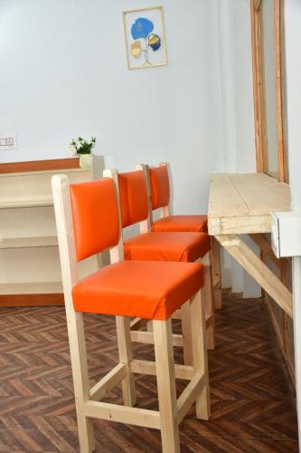 a group of orange chairs sitting at a table at The Desire Manali in Manāli