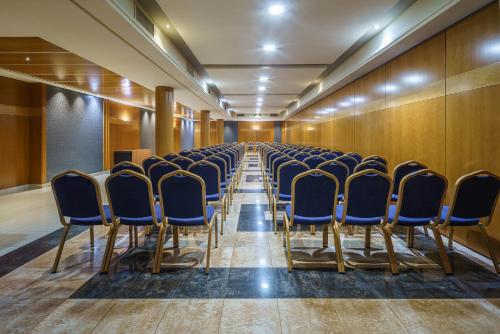 an empty conference room with blue chairs in a row at Exe Almería Centro in Almería