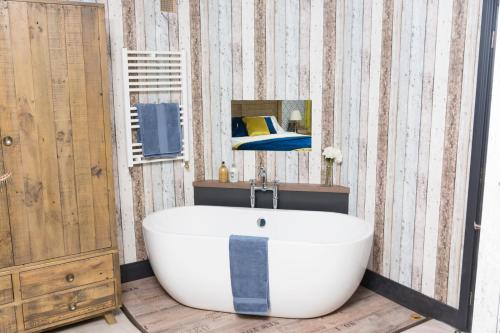 a bathroom with a white bath tub and a mirror at Mill Rythe Coastal Village in South Hayling