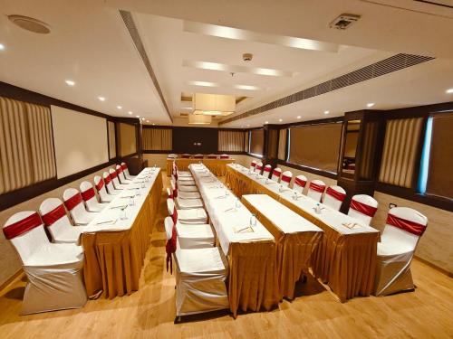 a conference room with tables and red chairs at MM Legacy - A Bergamont Hotel, Kanchipuram in Kanchipuram