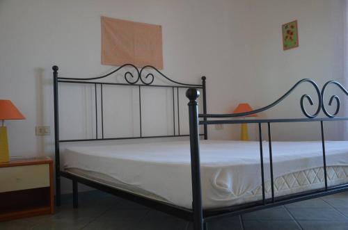 a bedroom with a black metal bed with white sheets at Casa vacanze vista mare a Budoni - sam01 in Tanaunella