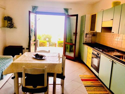 a small kitchen with a table and a table and chairs at Casa vacanze vista mare a Budoni - sam01 in Tanaunella