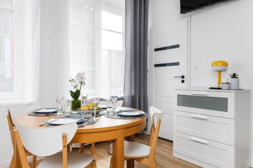 een eetkamer met een houten tafel en witte kasten bij Piwna Apartament in Gdańsk