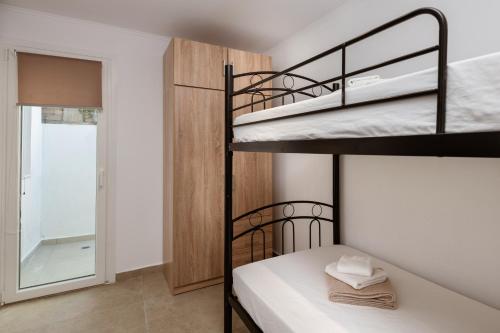 a bedroom with two bunk beds and a bathroom at M&A Boutique House in Zakynthos