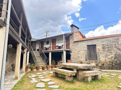 a stone building with a stone bench and stairs at Casa do Porco - Farm Stay & Spa no Douro in Melres