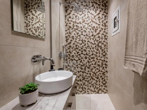 a bathroom with a white sink and a wall at M&A Boutique House in Zakynthos