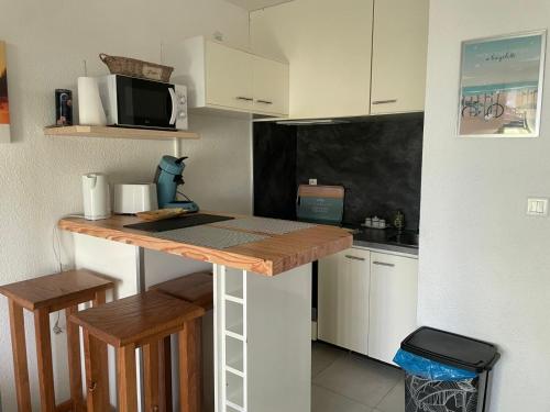 une petite cuisine avec un comptoir et un micro-ondes dans l'établissement Studio 212 lumineux à deux pas de l'océan, à Seignosse