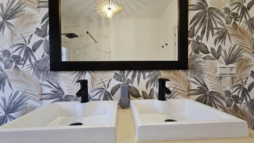 2 weiße Waschbecken im Bad mit Spiegel in der Unterkunft Casa Rural The Hope in La Puebla de Cazalla