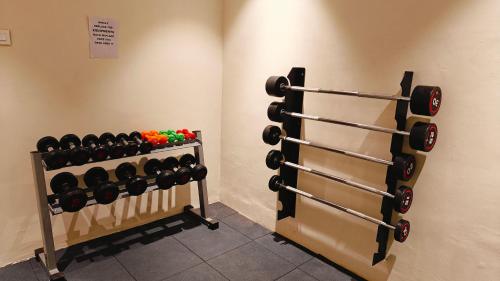 a room with a rack of dumbbells on the wall at MM Legacy - A Bergamont Hotel, Kanchipuram in Kanchipuram