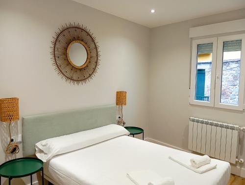 1 Schlafzimmer mit 2 Betten und einem Wandspiegel in der Unterkunft Apartamentos Marina Mar Vilagarcía 3000 in Villajuán