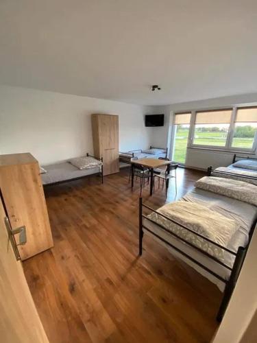 a room with beds and a table in it at Noclegi Rychwał in Rychwał