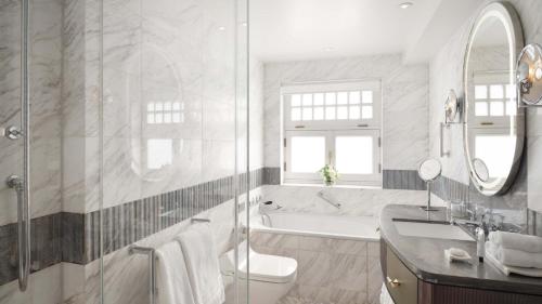 a bathroom with a tub and a toilet and a sink at Mandarin Oriental Hyde Park, London in London