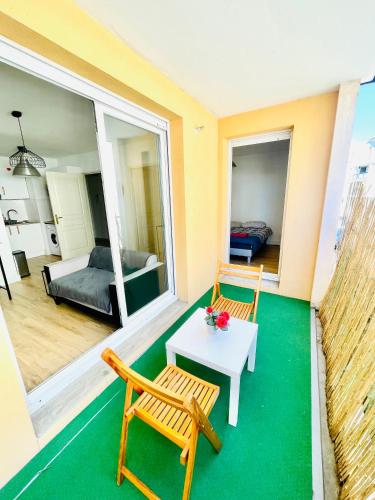 - une chambre avec deux chaises et une table dans l'établissement Appartement avec place de parking et piscine, à Villefranche-sur-Saône