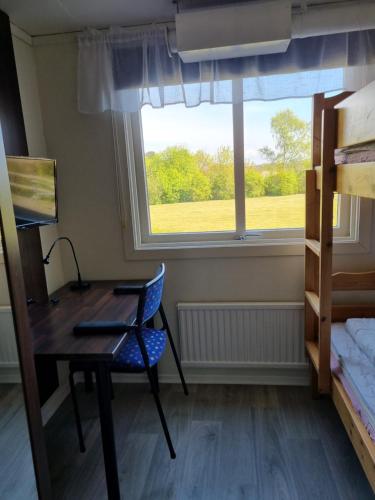 a bedroom with a desk and a chair and a window at Nyckelbo Vandrarhem in Helsingborg