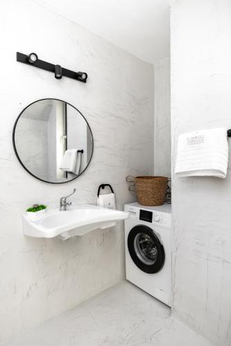 a bathroom with a washing machine and a sink at Flamingo Living Halkidiki - The Villas in Áyios Mámas