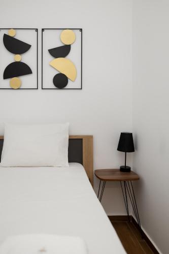 a bedroom with a white bed and a table at Flamingo Living Halkidiki - The Villas in Áyios Mámas