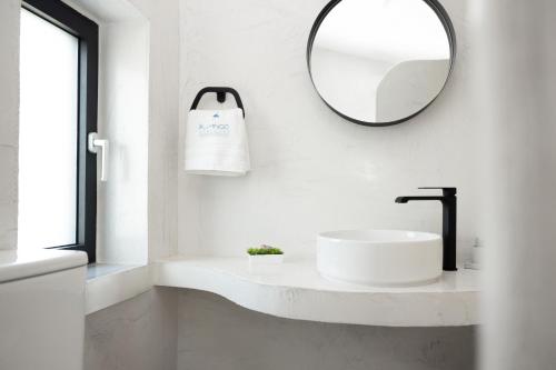 a white bathroom with a sink and a mirror at Flamingo Living Halkidiki - The Villas in Áyios Mámas