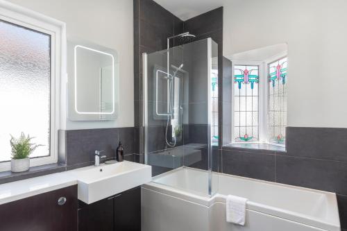 a bathroom with a sink and a tub and a mirror at Bright & Spacious 3bedroom Home in Brighton & Hove