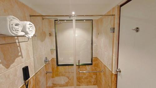 a shower with a glass door in a bathroom at MM Legacy - A Bergamont Hotel, Kanchipuram in Kanchipuram