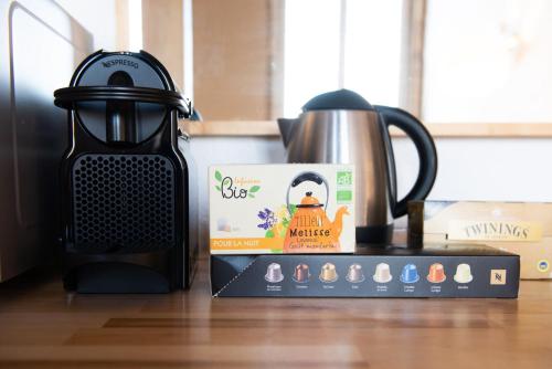 - un comptoir de cuisine avec une cafetière et une boîte dans l'établissement Le Woody authentique appartement des Canuts, à Caluire-et-Cuire