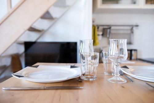 une table en bois avec des assiettes et des verres dans l'établissement Le Woody authentique appartement des Canuts, à Caluire-et-Cuire